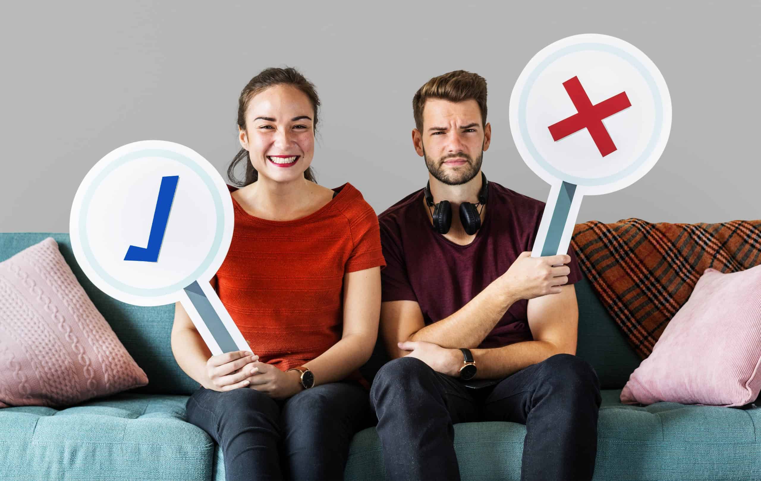 cheerful-couple-holding-vote-icon-sitting-couch-scaled-1.jpg