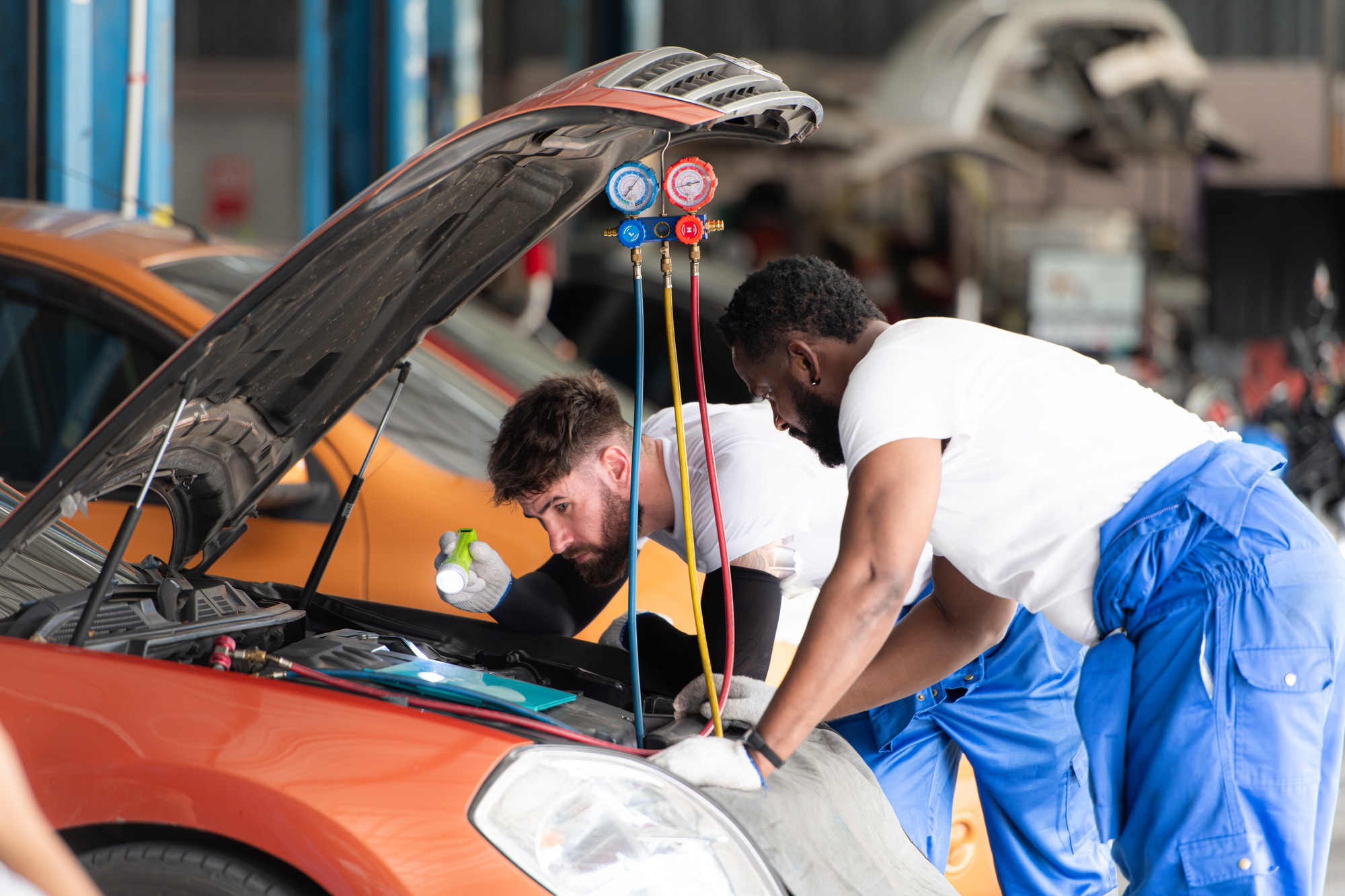 car-mechanic-working-in-an-auto-repair-shop-inspecting-the-operation-of-the-car-s-air-conditioner.jpg